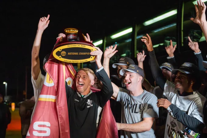 The MSU Texas Men's Soccer team celebrates joyously at night, holding up a trophy labeled "National Champion December 14, 2025."
