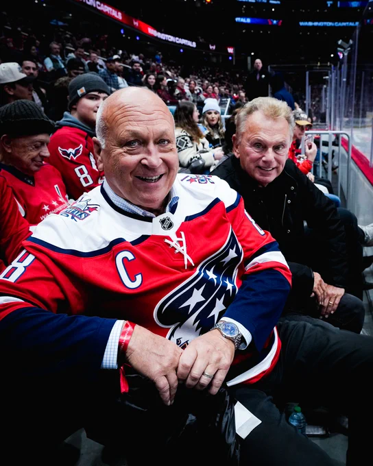 Cal Ripken, Jr. and Pat Sajak pose for a photo by the glass during tonight's game at Capital One Arena. 