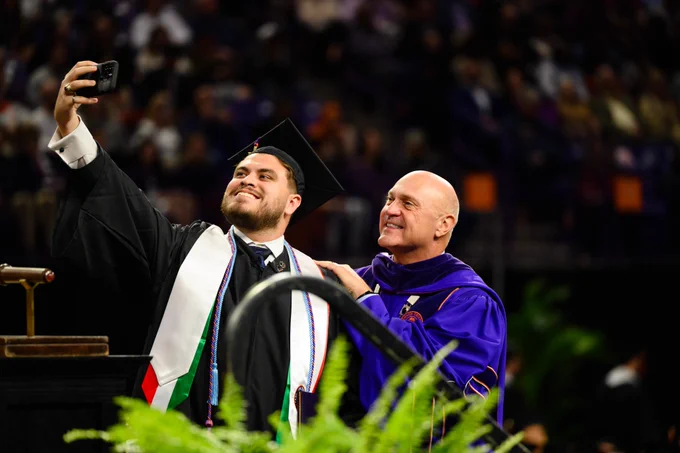 President Clements taking a selfie with a student at graduation.