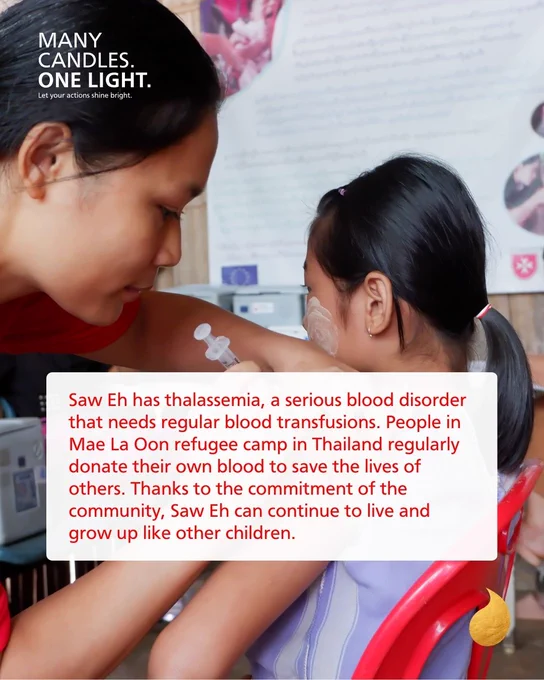 Two young children, one helping to administer an injection to the other's arm.