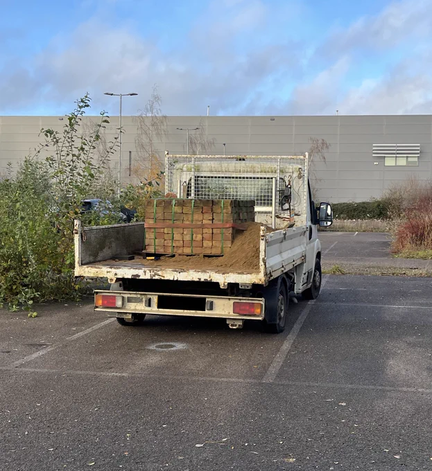 Overweight light goods vehicle carrying sand and bricks. No tailboard fitted which is not road safe compliant to ensure the load does not fall out.