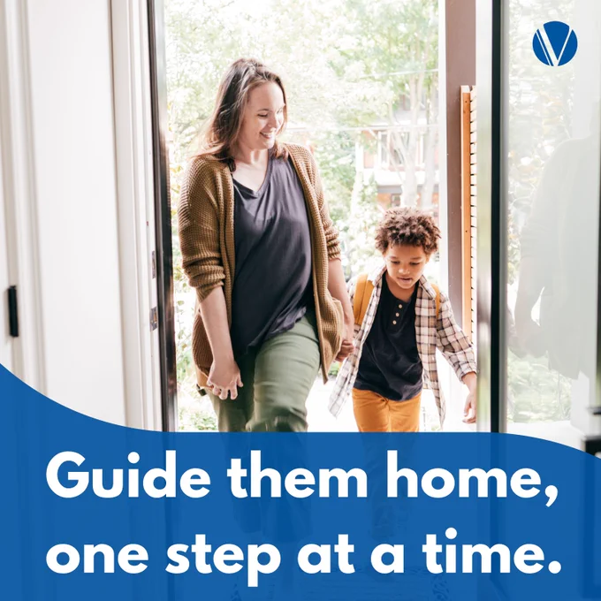 An adoptive mother and her adoptive child holding hands and smiling as they walk through a doorway with the text 'Guide them home, one step at a time.'