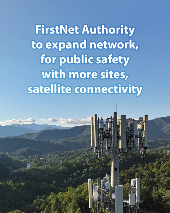 A cellular tower sits in the foreground overlooking rolling hills and a blue sky.