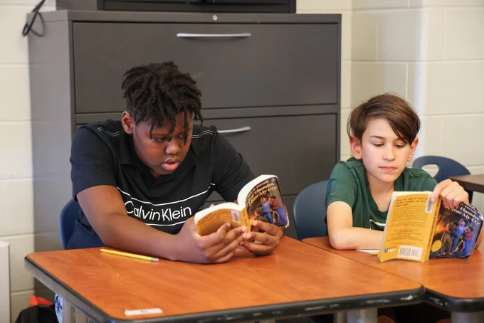 Two students read books.