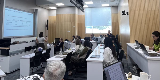 Marta Cota presenting her work on "“Gender Differences in Savings over the Lifecycle: The Role of Financial Literacy.” In the picture: Valentina Corradi, Fane Groes, Alessandra Voena, Jose-Victor Rios-Rull, Pamela Giustinelli, Matthias Deopke, Margherita Borella, Maria Cristina De Nardi, Arizo Karimi, Tetyana Surovtseva, Christian Aleman, Sagiri Kitao.