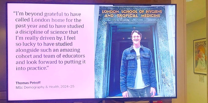 A testimony on a screen at LSHTM: "I'm beyond grateful to have called London home for the past year and to have studied a discipline of science that I'm really driven by. I feel so lucky to have studied alongside such an amazing cohort and team of educators and look forward to putting it into practice."

Thomas Petroff
MSc Demography & Health, 2024-25

Artwork can also be seen in the background.