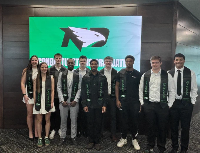 Fighting Hawk student-athletes posing with their graduation stoles.