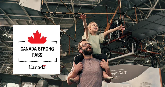 Kid with long blonde hair sits on dad's shoulders at the Canada Aviation and Space Museum both of them are smiling and looking up at an airplane. The Canada Strong Pass badge is in the left corner of the image.