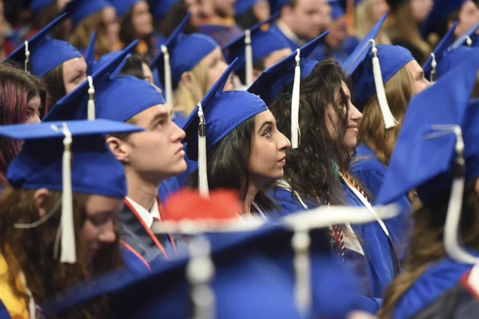 Group of graduates standing at commencement.