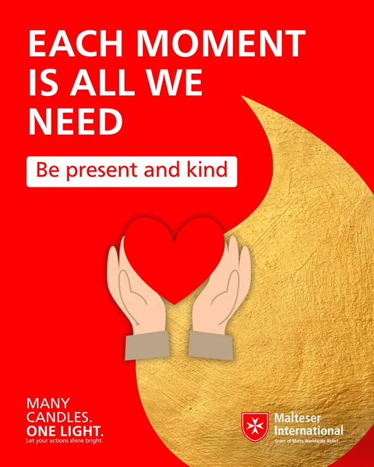 The image shows a red background with the text "EACH MOMENT IS ALL WE NEED" in large white letters. In the center is a golden heart shape held by two hands. Below the text is the Malteser International logo and a message encouraging people to "Be present and kind".