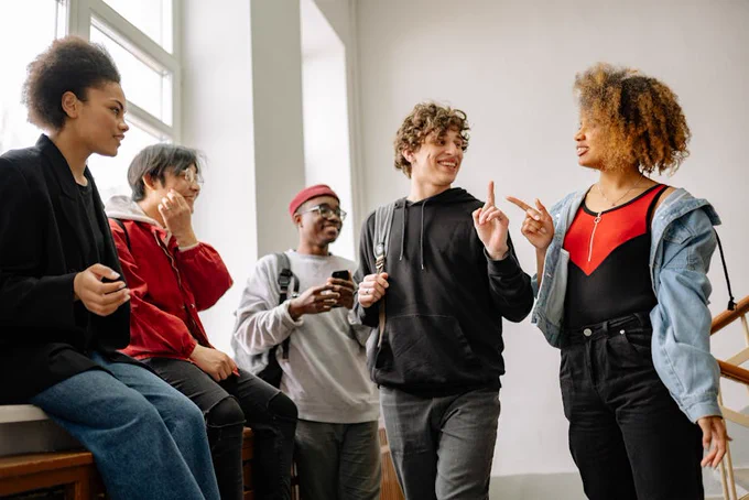 A lively group of friends enjoying a conversation indoors, highlighting diversity and connection.