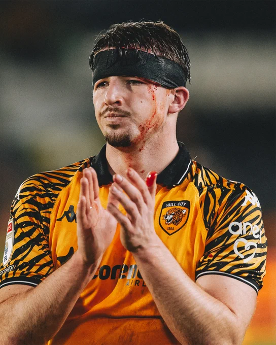 Charlie Hughes with his bandaged head clapping the fans