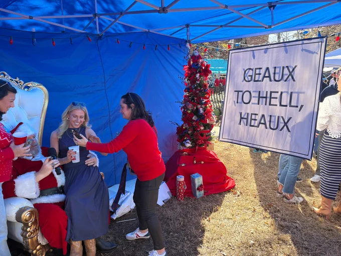 A man dressed like Santa Clause takes a photo with fans before Saturday's game in Oxford. Next to them is a "Geaux to Hell, Heaux" sign, a nod to Lane Kiffin, who was Public Enemy No. 1 after leaving Ole Miss for LSU in late November. 