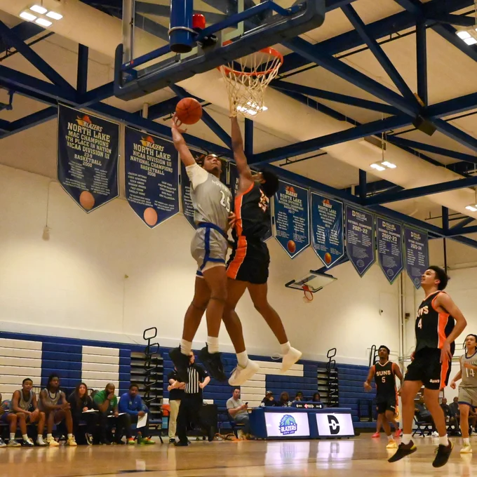 Dallas College North Lake men’s basketball player Romiel Carter soars toward the rim, where he is challenged by a Dallas College Cedar Valley defender.