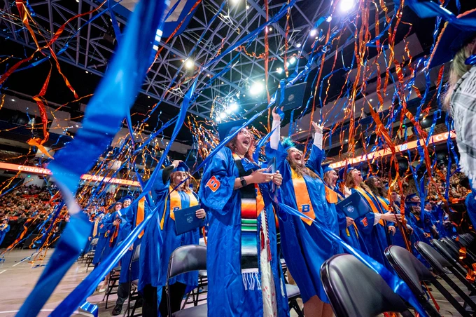 Boise State graduate students celebrating at the end of commencement. 
