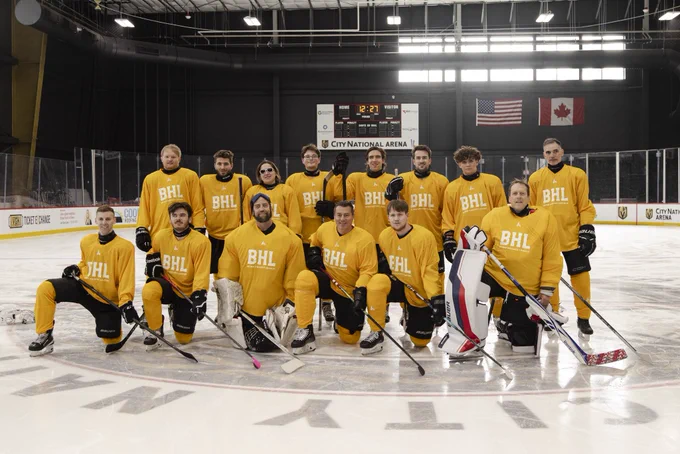 Team Mercurys is wearing black jerseys and pose on the ice with the scoreboard and the Canadian and American flag behind them