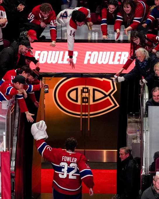 Jacob Fowler walking off the ice in Canadiens uniform surrounded by several Canadiens fans with their arms stretched out towards him