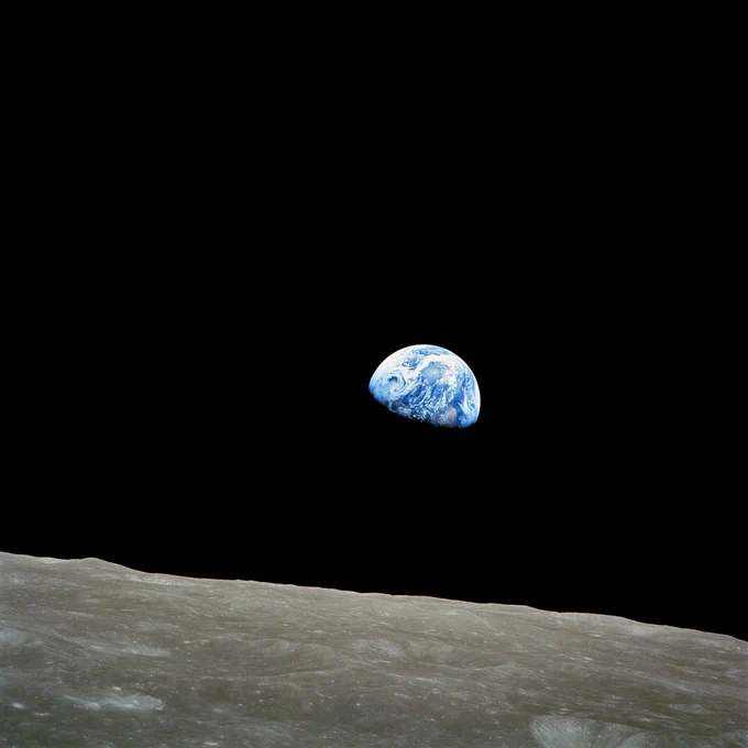 "Earthrise" photo taken by astronaut Bill Anders with the lunar surface in the foreground and the half-illuminated Earth in the background.