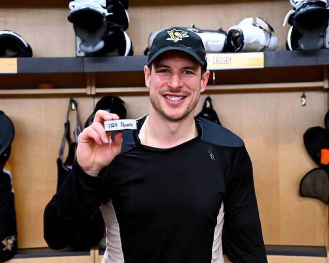 Sidney Crosby poses for a photo with a puck to commemorate his 1,724th career point. 