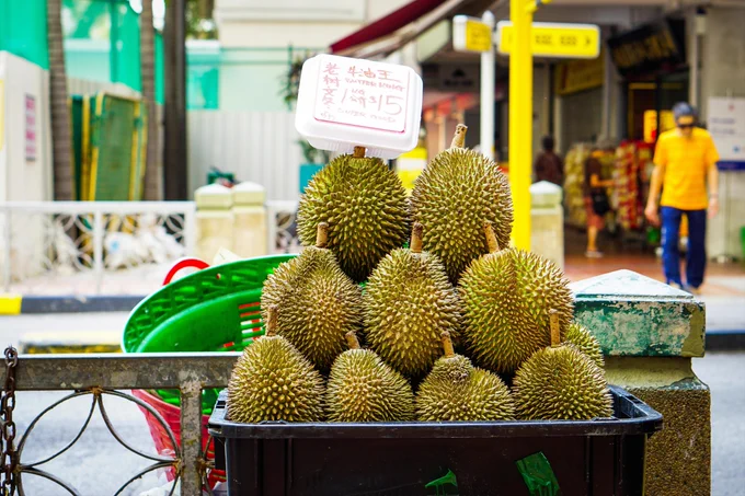 Photograph of a pile of durian fruits in a basket by the roadside in Singapore. By Aiva Apsite under a free Unsplash license: https://bit.ly/48TPgvv.