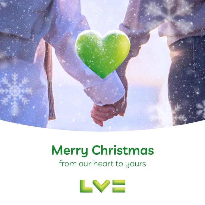 Two people holding hands against a snowy background. A green heart is in the middle. Text reads: 'Merry Christmas from our heart to yours', with the LV logo at the bottom.