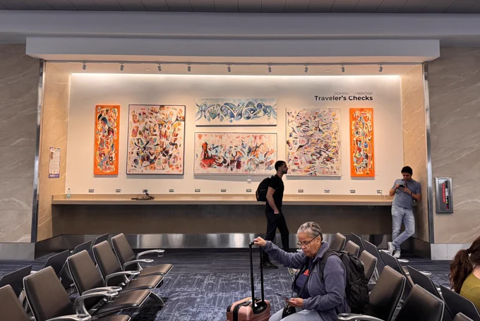 Colorful paintings on display in a passenger waiting area at FLL.
Dominik Ambroise, “Traveler's Checks"

