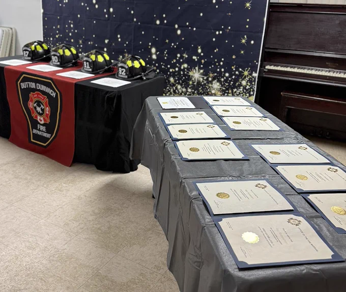 Photo of black firefighter helmets and certificates to be presented.