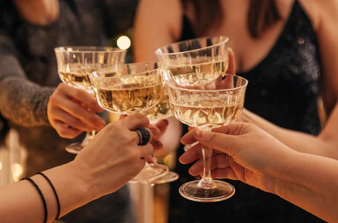 Group of individuals toasting with champagne glasses at a celebration.