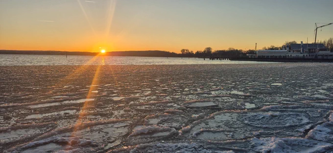 Hinten: Sonnenuntergang am Ammersee, vorne: Ufer gefroren