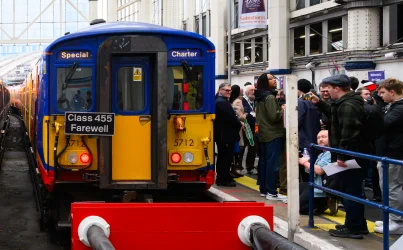 A Class 455 train with the headboard 'Class 455 Farewell' at a station, surrounded by a crowd of spectators.
