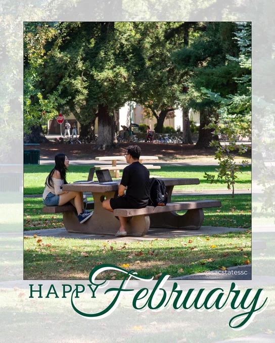 Two students sit across from each other at a picnic table on a tree-lined campus lawn, laptops open as they talk, with “Happy February” text overlaid at the bottom