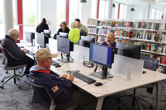 People sit at computers in the Riviera Beach Library.
