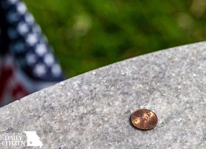 A penny left on a headstone at the the Springfield National Cemetery serves as a message to the deceased’s family that he or she had a visitor. (Photo by Jym Wilson)