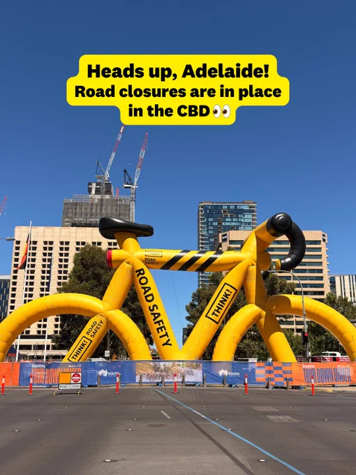 Promotional image featuring a large yellow bicycle sculpture with black detailing, indicating road closures in the CBD of Adelaide for a road safety event.