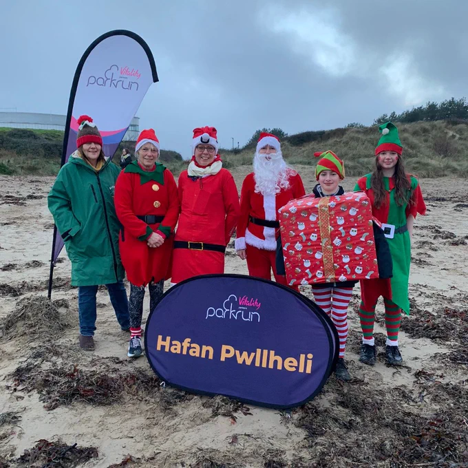 Group of parkrunners wearing Christmas clothing at Hafan Pwllheli parkrun