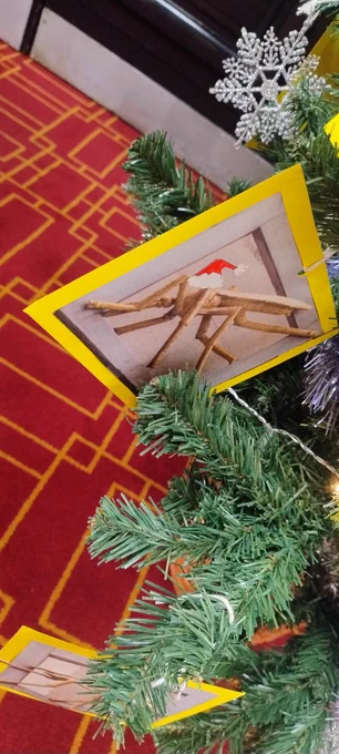 A gilded mosquito vector on the tree surrounded by decorations on the tree.