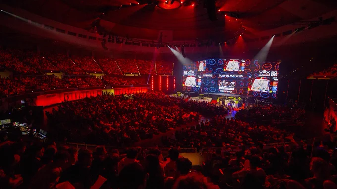 The VEX Arena filled with spectators is bathed in red light during the 2025 VEX Robotics World Championship.
