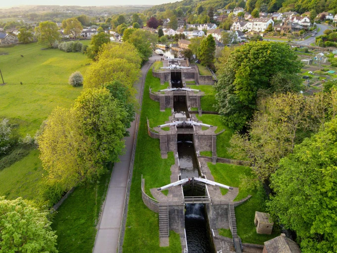 Bingley Five Rise Locks from above. The lock beams stand uniform in white against the green surroundings. 