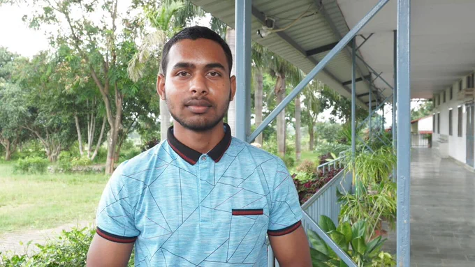 Yashwant in a sky blue polo shirt stands outside the TPRF Food for People facility in Bantoli, India