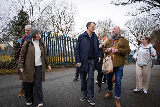 A group of adults walking and chatting happily in a suburban setting in Blackpool, including Simon Hayes, CEO, Sport England in the centre.