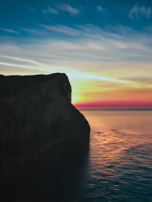 Sunrise peeking behind the cliffs at Seaford Head, which eventually lead to Beachy Head, Eastbourne.