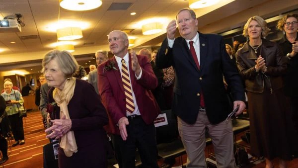 Duncanson (second from left) and Huebsch (third from left) take part in the Minnesota Rouser at Alumni Awards Affair 2025. 