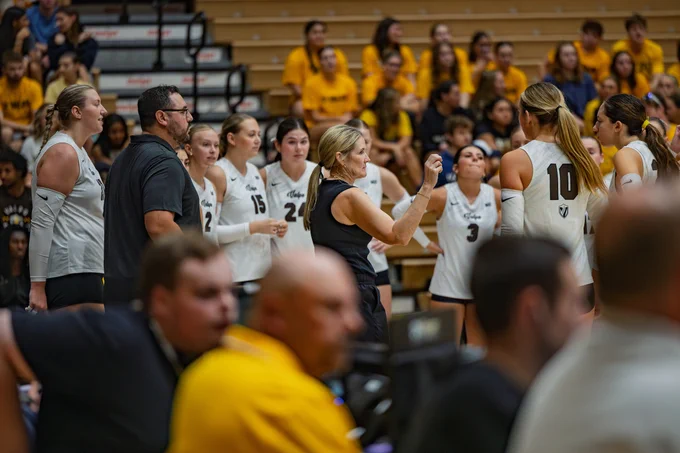 The Valpo volleyball team congregates around Coach Carin Avery during a match.