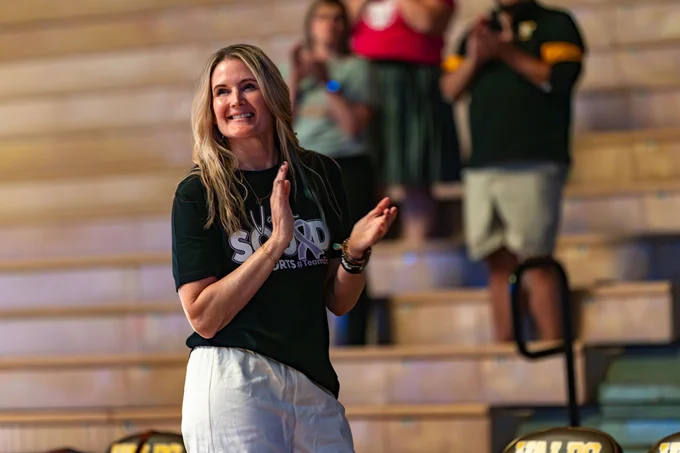 Valpo Volleyball Coach Carin Avery claps on courtside during a match.