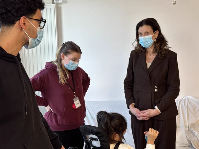 Photographie de la ministre discutant avec deux personnes.
