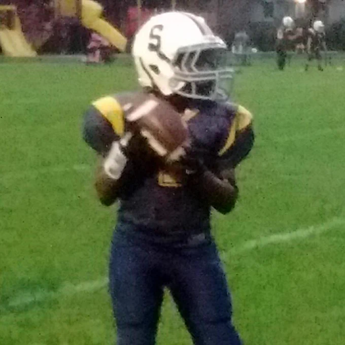 Nine-year-old Shekai Mills-Knight carries the football in both hands.