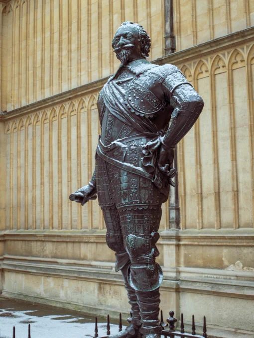 Statue of the Earl of Pembroke outside of the Old Bodleian Library. The statue has a sprinkling of snow on the top 