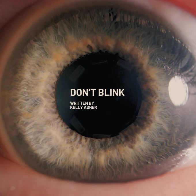 ECU of a blue eye. 
In white text: DON'T BLINK Written by Kelly Asher