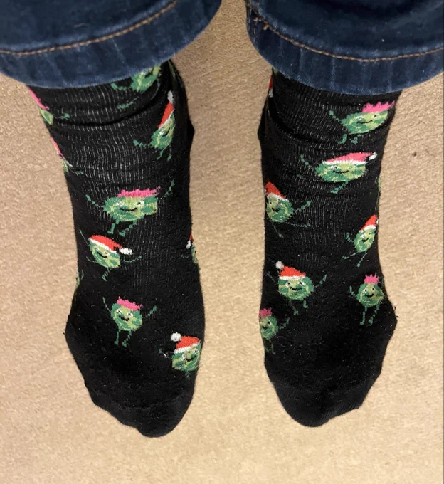 Black Christmas socks with sprouts in Santa hats.