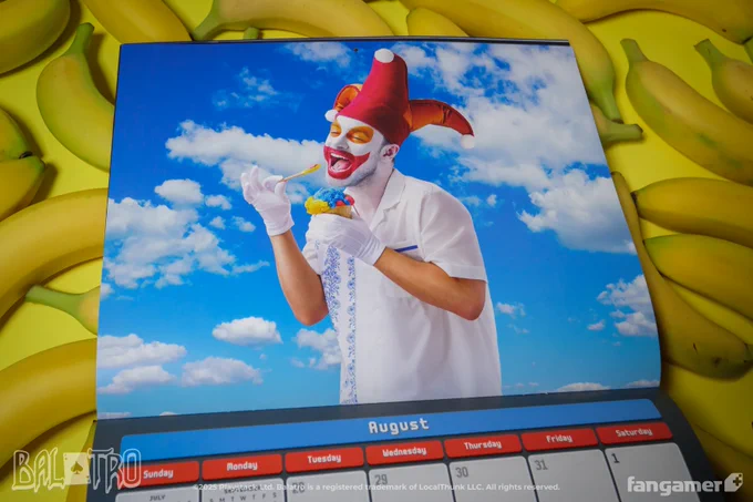 A photo of the August spread in the Balatro 2026 Wall Calendar, featuring Jimbo eating a snowcone against a summer sky. 